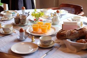 einen Tisch mit Eiern und Tassen Orangensaft in der Unterkunft Le Couvent de Neuviale in Parisot