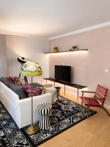 a living room with a white couch and a television at CentralStay Tours Centre Gare - Ouverture Aout '26 in Tours