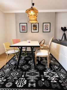 a dining room with a table and chairs on a rug at CentralStay Tours Centre Gare - Ouverture Aout '26 in Tours