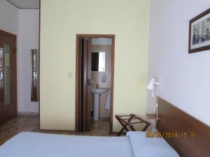 a bedroom with a bed and a sink and a bathroom at Pensione Aurora in Imperia