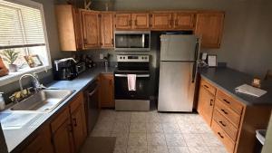 a kitchen with stainless steel appliances and wooden cabinets at Lies by AvantStay in North Creek