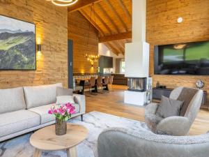 a living room with a couch and chairs and a tv at Dachstein Grand Alpine Lodge in Mitterberg-Schladming-Dachstein