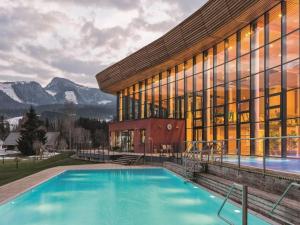 a house with a swimming pool in front of a building at Dachstein Grand Alpine Lodge in Mitterberg-Schladming-Dachstein
