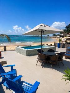 a table and chairs with an umbrella on the beach at Pousada Morena in Morro de São Paulo