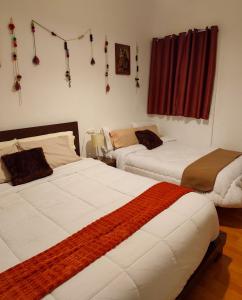 a bedroom with two beds and decorations on the wall at KANTIQ House in Cusco
