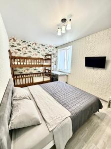 a bedroom with a bed and a flat screen tv at Apartment Synergia 3 in Irpin
