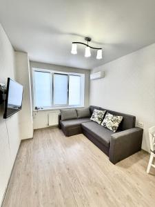 a living room with a couch and a flat screen tv at Apartment Synergia 3 in Irpin