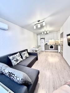 a living room with a couch and a kitchen at Apartment Synergia 3 in Irpin