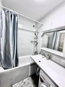 a bathroom with a shower curtain and a sink at Apartment Synergia 3 in Irpin +15 photos