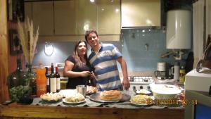 Ein Mann und eine Frau stehen in einer Küche mit Essen in der Unterkunft La Casa del Tata in Potrerillos