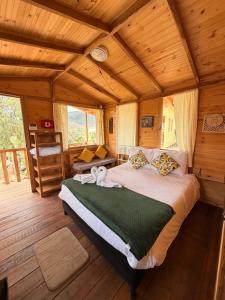 a bedroom with a bed in a wooden cabin at Glamping Entre Nopales - Sáchica cerca a Villa de Leyva in Sáchica