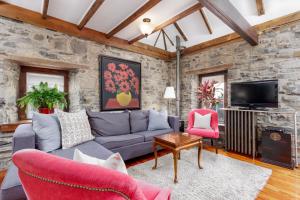 a living room with a stone wall at All Suites Whitney Manor in Kingston