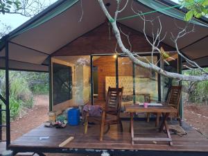 a tent with a table and chairs on a deck at Wilpattu Wilderness Camping in Wilpattu +48 photos