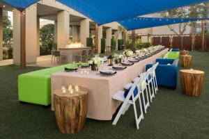 a long table with white tables and chairs and blue chairs at San Diego Marriott Mission Valley in San Diego