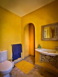 La salle de bains jaune est pourvue de toilettes et d'un lavabo. dans l'établissement Riad Oasis 3, à Marrakech