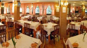 restauracja z białymi stołami i krzesłami w pokoju w obiekcie Abba Camere w mieście Borgaro Torinese