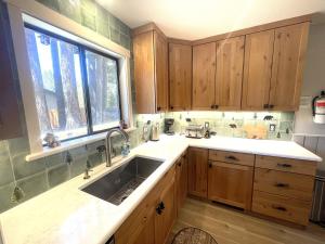 a kitchen with wooden cabinets and a sink and a window at Bear Claw Trails in Lake Tahoe Airport +35 photos