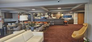 a restaurant with couches and chairs and a bar at Hotel 10 São Leopoldo in São Leopoldo