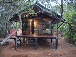 a small building with a table in a forest at Wilpattu Wilderness Camping in Wilpattu