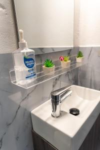 a bathroom sink with a bottle of soap and plants at Kassuky Home in Cabarete +57 photos