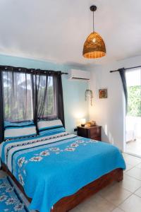 a bedroom with a bed with a blue comforter at Kassuky Home in Cabarete