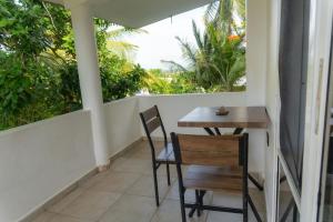 a balcony with a table and chairs and trees at Kassuky Home in Cabarete