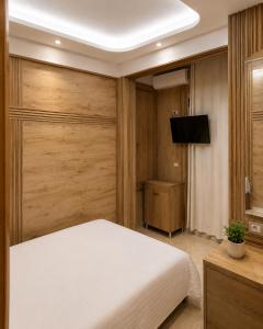 a bedroom with a white bed and a television at ANN World in Vlorë