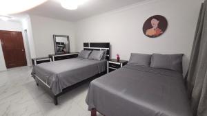 a bedroom with two beds and a clock on the wall at Apartamento acogedor con equipamiento premium in El Café