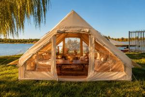 a tent in the grass next to a body of water at Superbe Tente Luxeuse in Neuilly-sur-Marne