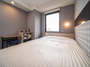 a bedroom with a large white bed and a window at Super Hotel Anan City Hall Smoke-Free in Anan