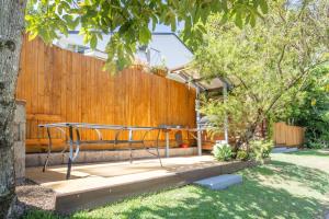 a garden with a bench and a fence at Koala Lodge Studio 2 in Iluka +3 photos