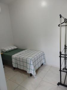 a bed sitting in a corner of a room at Seis Quarto Hospedaria - Suíte Com Ar ou Ventilador - Self Checkin - Centro in Juazeiro do Norte +11 photos