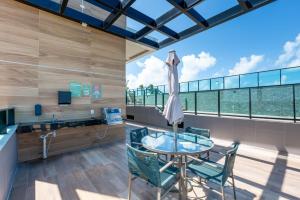 an office with a glass table and chairs and a large window at Beachfront flat at Porto de Galinhas beach, close to the natural pools. in Porto De Galinhas