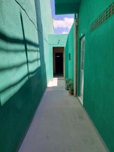 an empty alley with green walls and a hallway at Seis Quarto Hospedaria - Suíte Com Ar ou Ventilador - Self Checkin - Centro in Juazeiro do Norte
