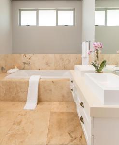 a bathroom with two sinks and a bath tub at 17 Feverberry in Ballito