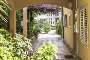 an empty walkway with flowers hanging from a building at Apartments Iva in Orebić