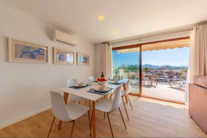 a dining room with a white table and chairs at Seafront Marina 1 Apartment in Pollença +27 photos