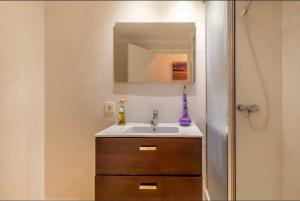 a bathroom with a sink and a mirror at Seafront Marina 1 Apartment in Pollença