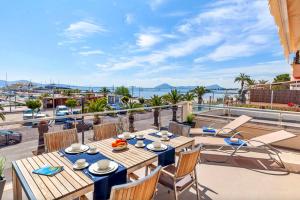 a table on a balcony with a view of the ocean at Seafront Marina 1 Apartment in Pollença