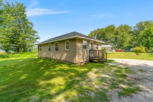 a small house on a grassy field with trees at Fishing Kayaks Firepit Paddleboat in Pierceton +26 photos