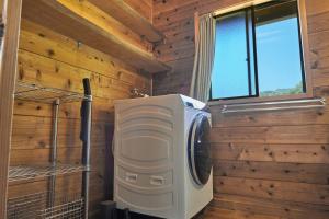 a washer and dryer in a room with wooden walls at Koguchi Village by WhyKumano in Shingū