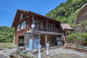 a wooden house with a balcony on a mountain at Koguchi Village by WhyKumano in Shingū