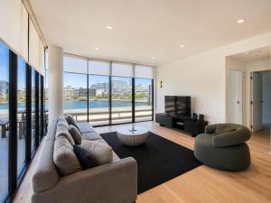 a living room with a couch and a television at The Sebel Residences Melbourne Docklands Serviced Apartments in Melbourne