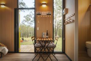a dining room with a table and chairs in front of a door at Three-Kalm & Four-Sol by Tiny Away in Rainbow Flat