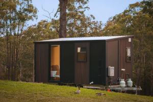 a green and brown tiny house on a hill at Three-Kalm & Four-Sol by Tiny Away in Rainbow Flat +17 photos
