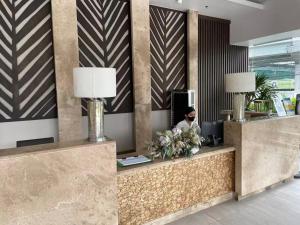 a lobby with a reception desk with a person in the background at Infina Towers in Manila +25 photos