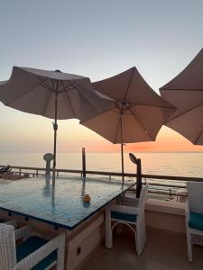 a table with two umbrellas and chairs and the ocean at Best Sea View in Morocco in Sidi Bouqnadel