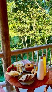 a table with bread and pastries on top of it at Suíte em Trindade, Praia Brava, na Mata in Paraty