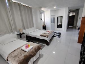 a hotel room with two beds with flowers on a tray at Galápagos Apartments in Puerto Ayora