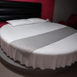 a bed with white sheets and pillows in a room at DLUXO hotel in Lima